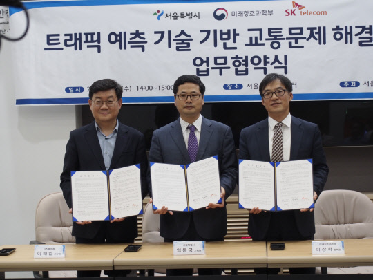 미래창조과학부와 서울시, SK텔레콤은 28일 교통량 예측 SW 개발을 위한 업무협약을 체결했다고 밝혔다. 이상학 미래부 SW정책관(오른쪽부터), 임동국 서울시 보행친화기획관, 이해열 SK텔레콤 본부장이  기념촬영을 하고 있다.  미래부 제공